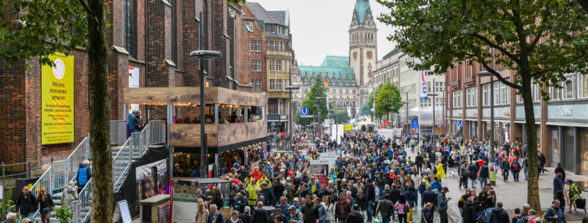 Das Bild zeigt die Hamburger Mönckebergstraße während der Veranstaltung zum Tag der Deutschen Einheit in 2023 mit Ständen und Besuchenden.